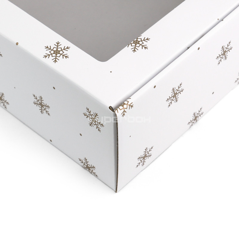 Weiße Geschenkbox mit goldenen Schneeflocken und Fenster